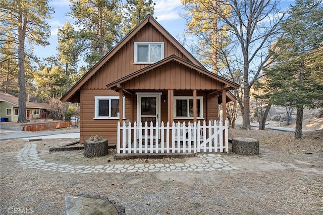 chalet / cabin with covered porch and a fenced front yard