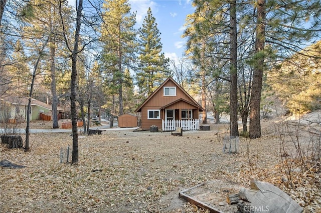 back of house featuring an outbuilding, covered porch, and a storage shed