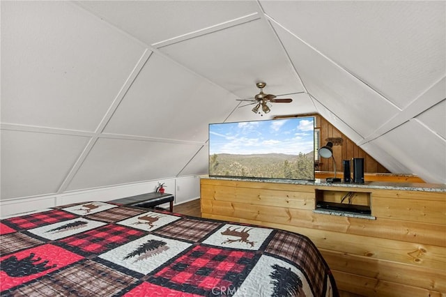 bedroom with lofted ceiling and wooden walls