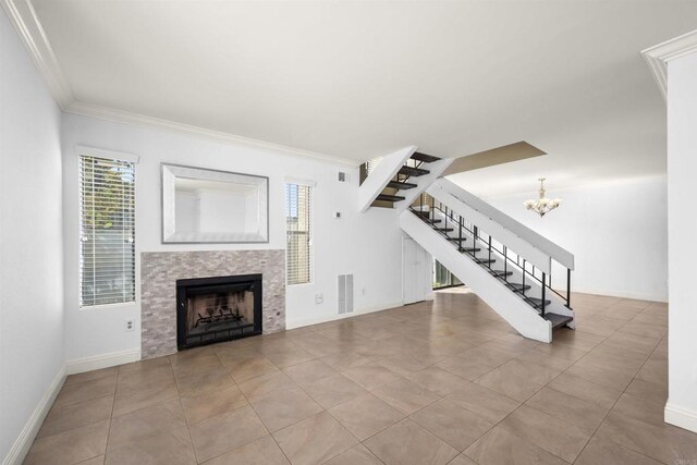 living area with crown molding, a fireplace, stairway, an inviting chandelier, and baseboards