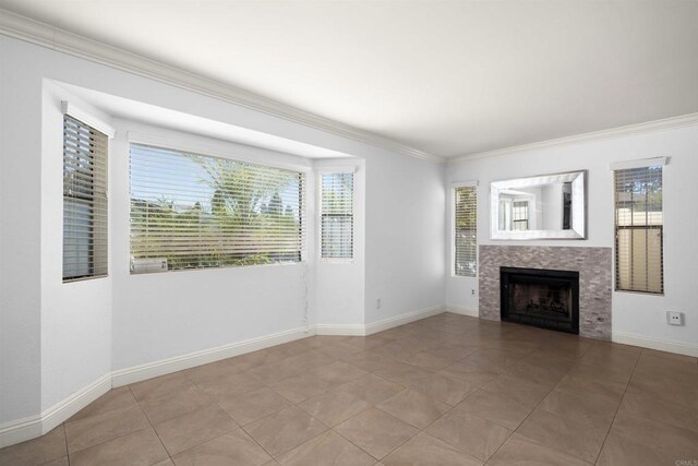 unfurnished living room featuring ornamental molding, light tile patterned flooring, a fireplace, and baseboards