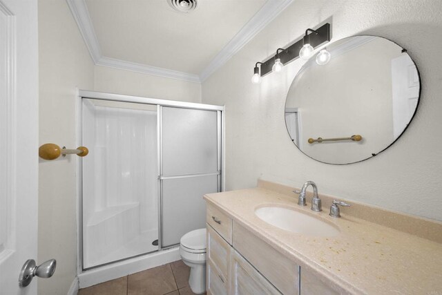 bathroom with tile patterned flooring, toilet, visible vents, a shower stall, and crown molding