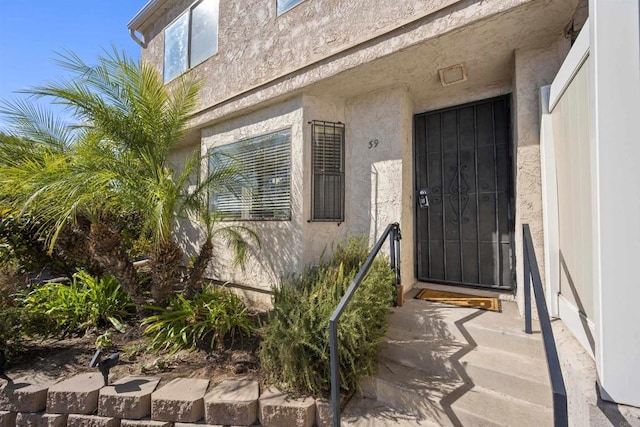 view of exterior entry with stucco siding