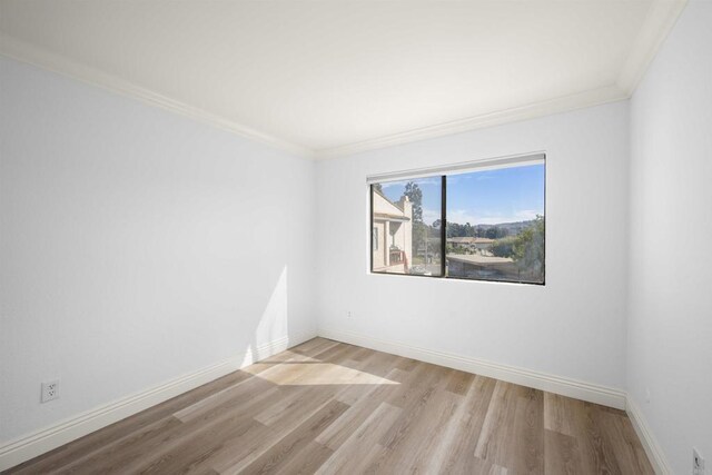 unfurnished room with light wood-style flooring, baseboards, and crown molding