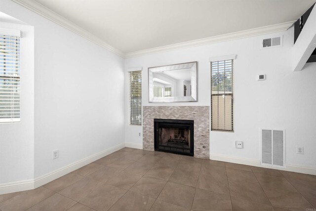 unfurnished living room featuring baseboards, a tile fireplace, visible vents, and crown molding