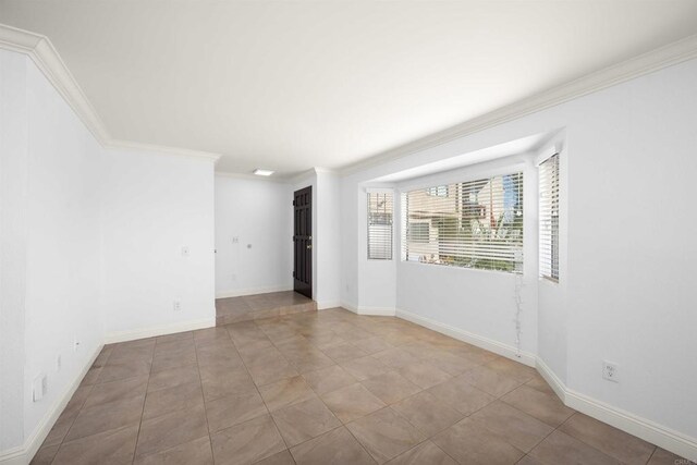 unfurnished room with light tile patterned floors, baseboards, and crown molding