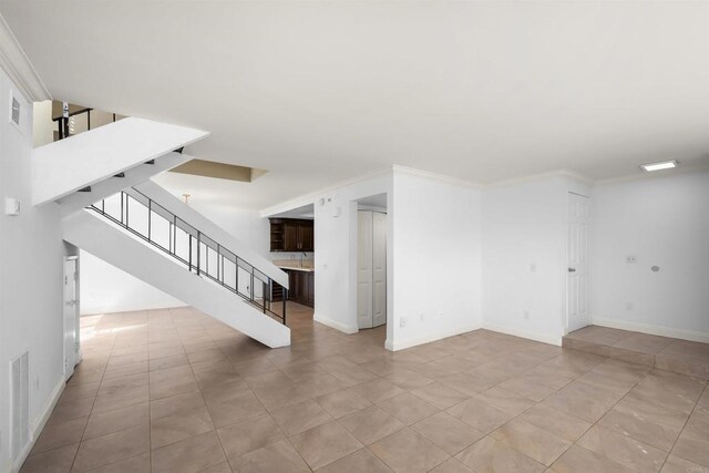 empty room with stairs, ornamental molding, visible vents, and baseboards