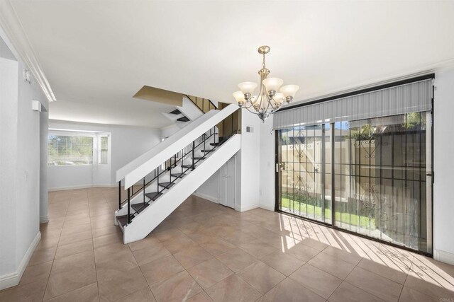 unfurnished dining area with tile patterned floors, stairway, baseboards, and an inviting chandelier