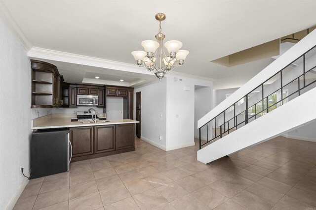 kitchen featuring light countertops, appliances with stainless steel finishes, ornamental molding, dark brown cabinets, and pendant lighting