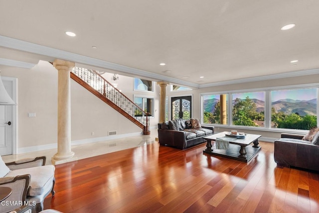 living room with ornamental molding, a mountain view, decorative columns, and hardwood / wood-style floors