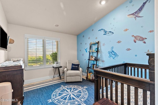 bedroom featuring a nursery area and lofted ceiling