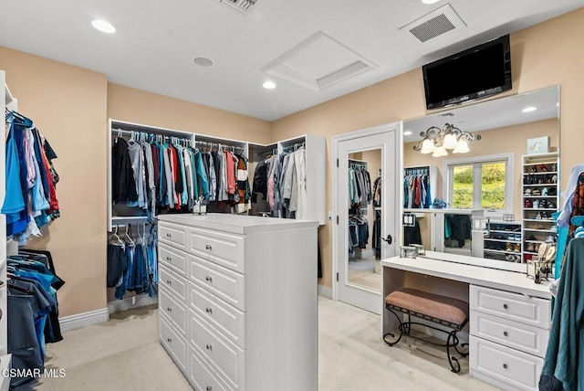 walk in closet featuring light carpet