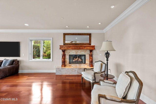 sitting room with hardwood / wood-style floors, a high end fireplace, and ornamental molding