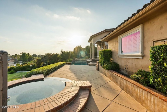 view of patio / terrace with an in ground hot tub