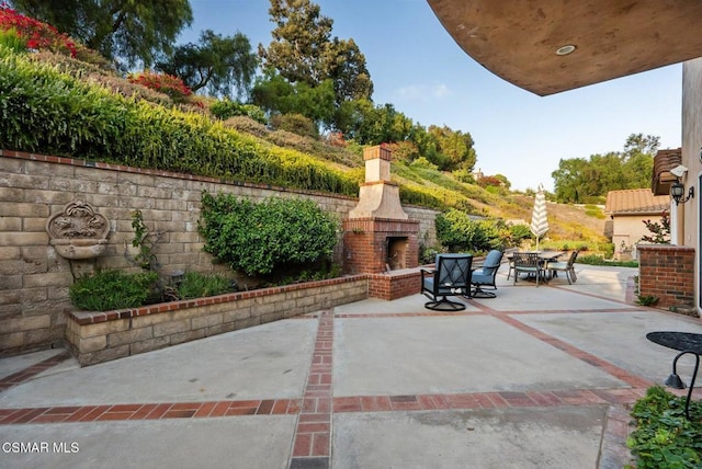 view of patio / terrace with an outdoor brick fireplace