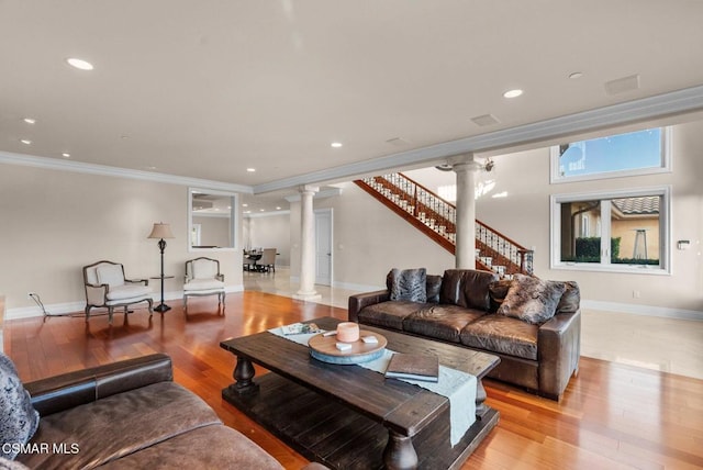 living room with crown molding, light hardwood / wood-style floors, and decorative columns