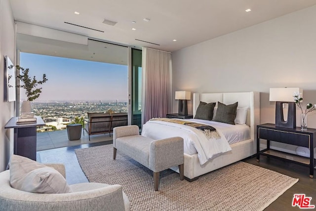 bedroom with hardwood / wood-style floors, access to outside, and expansive windows