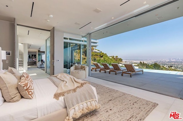 bedroom featuring access to outside, expansive windows, and light tile patterned flooring