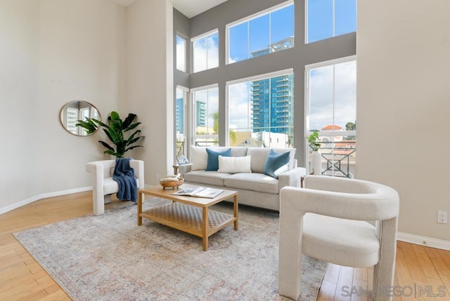 living room with light hardwood / wood-style flooring and a high ceiling