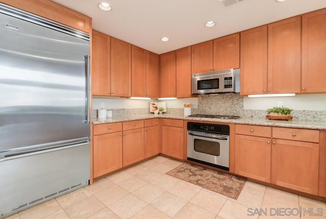 kitchen with light stone counters and stainless steel appliances