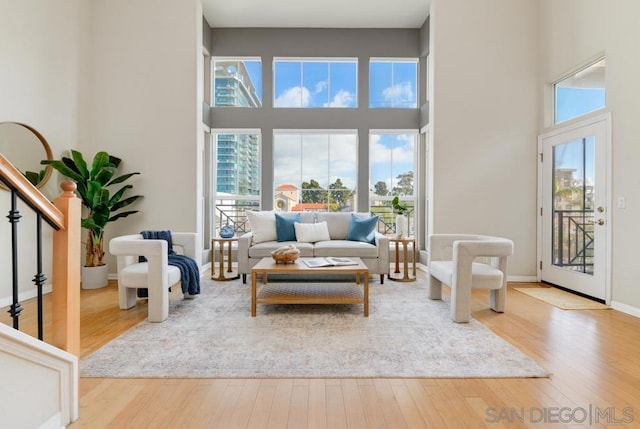 living room with a towering ceiling and light hardwood / wood-style floors