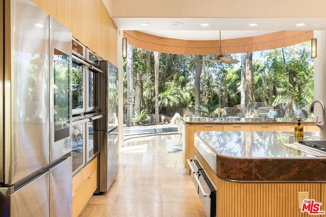 kitchen with hanging light fixtures, light tile patterned flooring, fridge, and stainless steel refrigerator