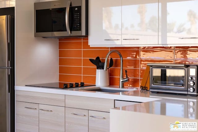 kitchen featuring stainless steel appliances, sink, and decorative backsplash