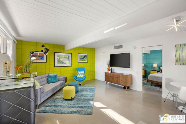 living room with beamed ceiling and concrete floors