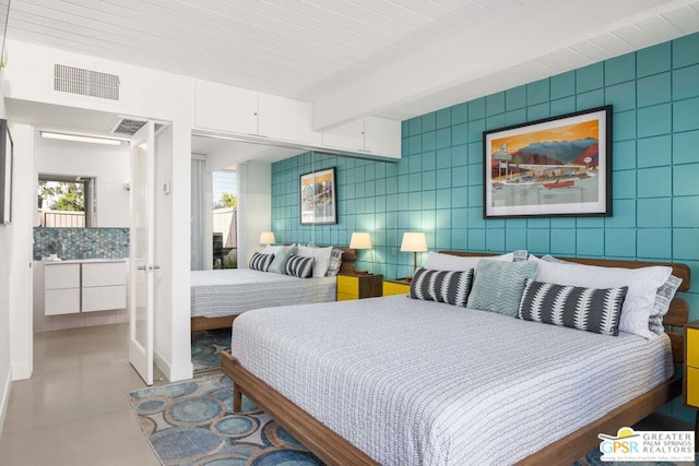 bedroom featuring beam ceiling and tile walls