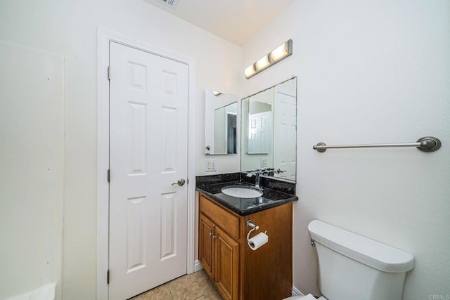 bathroom with toilet, tile patterned flooring, and vanity