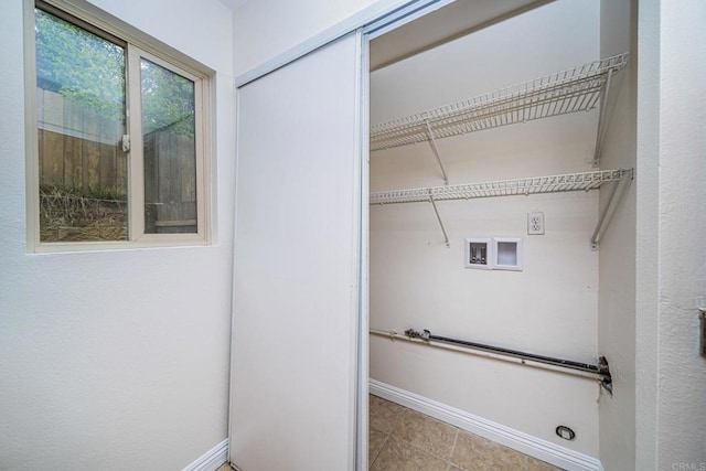 laundry area featuring baseboards, tile patterned floors, laundry area, and hookup for a washing machine
