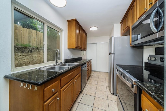 kitchen featuring brown cabinetry, a sink, and stainless steel appliances