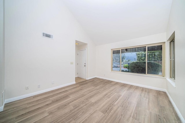 unfurnished room with light wood-type flooring, high vaulted ceiling, baseboards, and visible vents