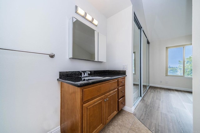bathroom with baseboards, vanity, and tile patterned floors