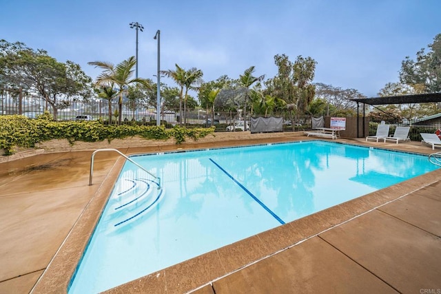 community pool featuring fence and a patio area