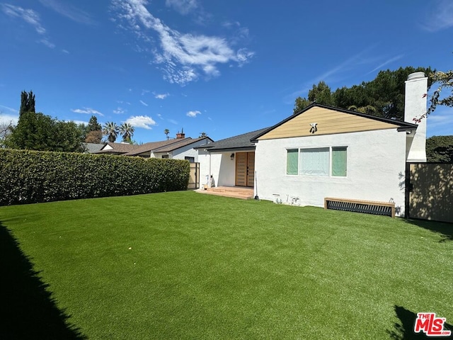 rear view of property featuring a yard