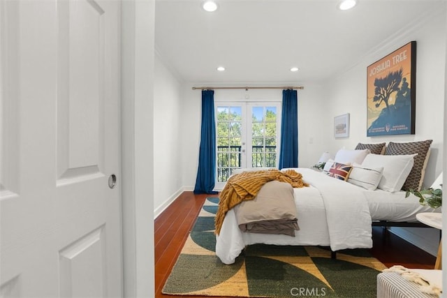 bedroom with crown molding, wood-type flooring, and access to exterior