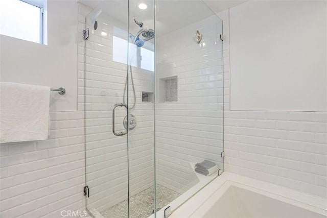 bathroom featuring a shower with door