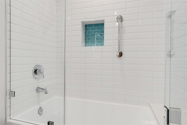 bathroom with bath / shower combo with glass door