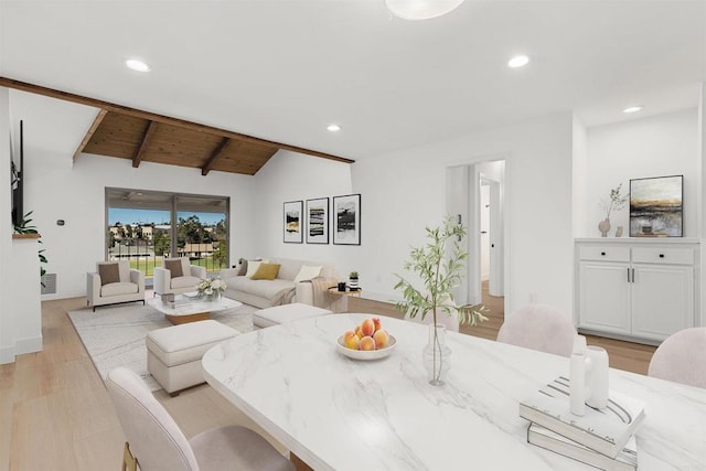 dining room with light hardwood / wood-style floors and lofted ceiling with beams