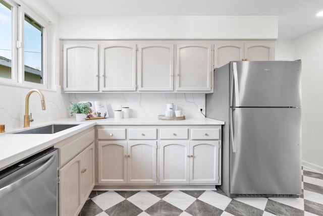 kitchen featuring white cabinetry, appliances with stainless steel finishes, sink, and decorative backsplash