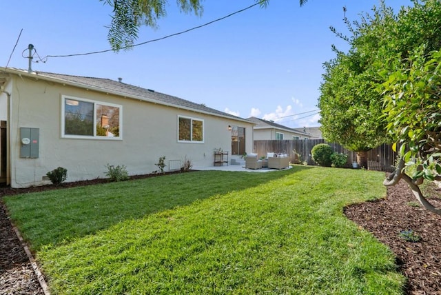 back of house with an outdoor living space, a lawn, and a patio area