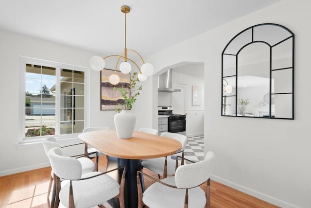 dining space with an inviting chandelier and light hardwood / wood-style floors