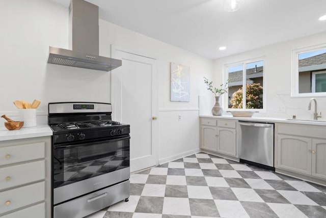 kitchen with sink, stainless steel appliances, and wall chimney exhaust hood