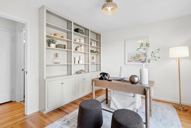 home office with light hardwood / wood-style flooring