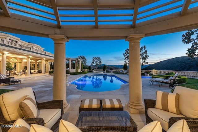 view of pool featuring a mountain view, an outdoor hangout area, and a patio area