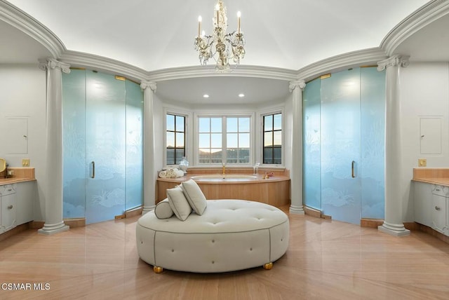 bathroom with crown molding, vanity, a chandelier, and ornate columns