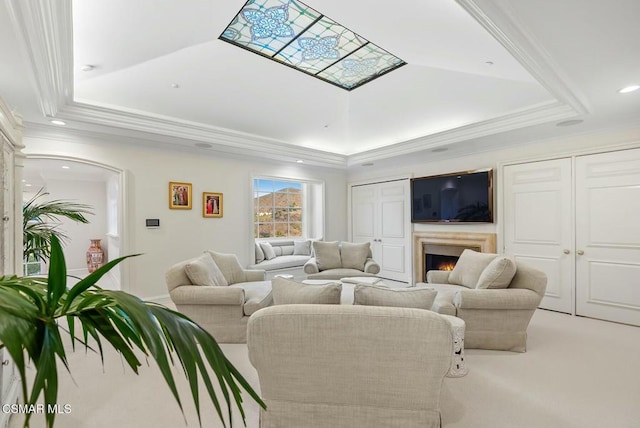 living room featuring a raised ceiling, crown molding, and carpet flooring