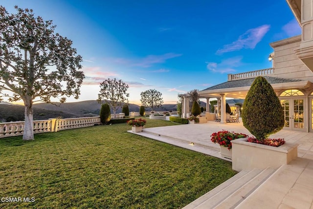 yard at dusk with a patio area