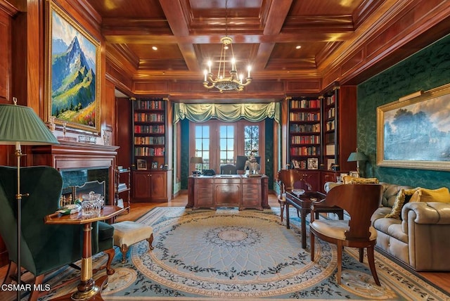 sitting room featuring a chandelier, coffered ceiling, a premium fireplace, wooden ceiling, and built in shelves